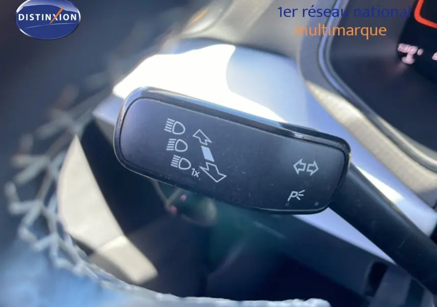 Gros plan sur la commande de clignotants et feux du SEAT Arona 2025, intérieur gris et noir visible en arrière-plan.