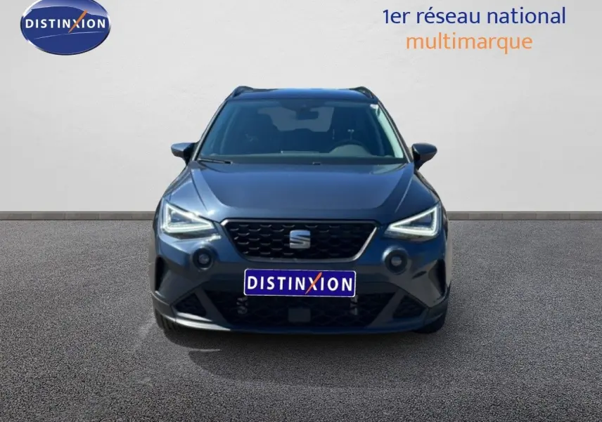 Vue avant d'un SEAT Arona 2025 gris Magnetic Metal avec toit noir, phares LED allumés sur fond neutre.