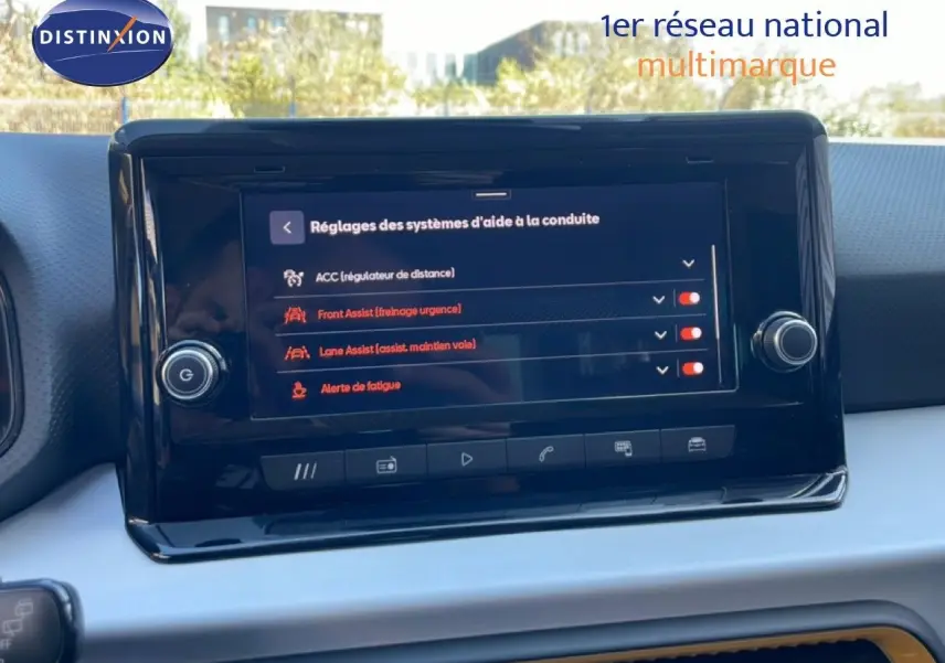 Vue intérieure centrée sur l'écran tactile du tableau de bord du SEAT Arona 2025, affichant les aides à la conduite.