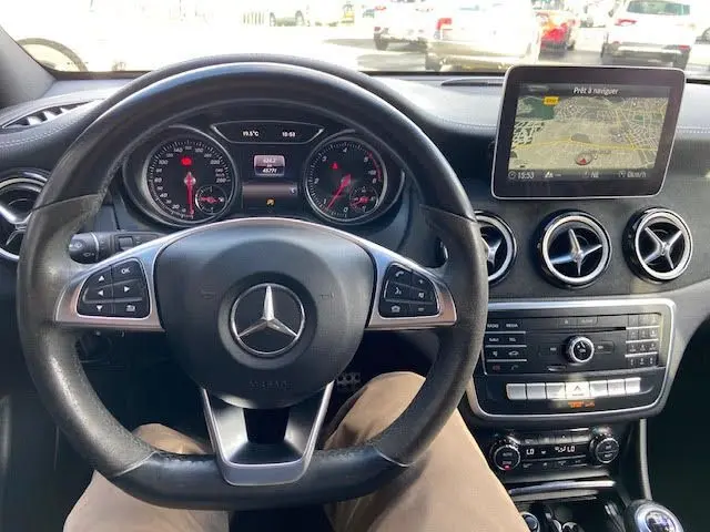 Vue intérieure centrée sur le volant Mercedes CLA Shooting Brake 200D 2017 avec tableau de bord et écran GPS allumé.