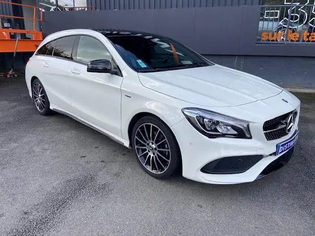 Mercedes Classe CLA Shooting Brake 200D WhiteArt blanche vue 3/4 avant avec toit noir et jantes AMG bicolores.