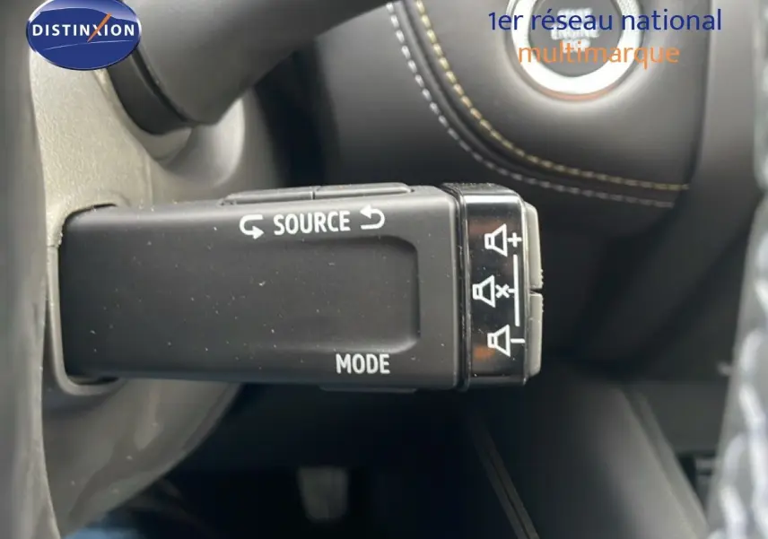 Gros plan sur la commande audio au volant du Renault Symbioz noir étoile métal, avec boutons source et mode visibles.