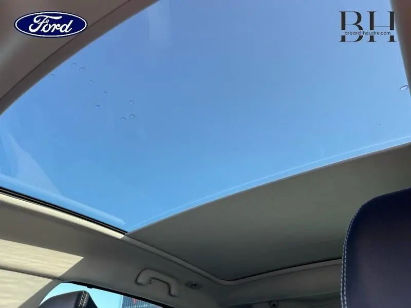 Toit panoramique ouvert sur ciel bleu visible depuis l'intérieur d'un Renault Scenic blanc nacré/noir étoilé 2017
