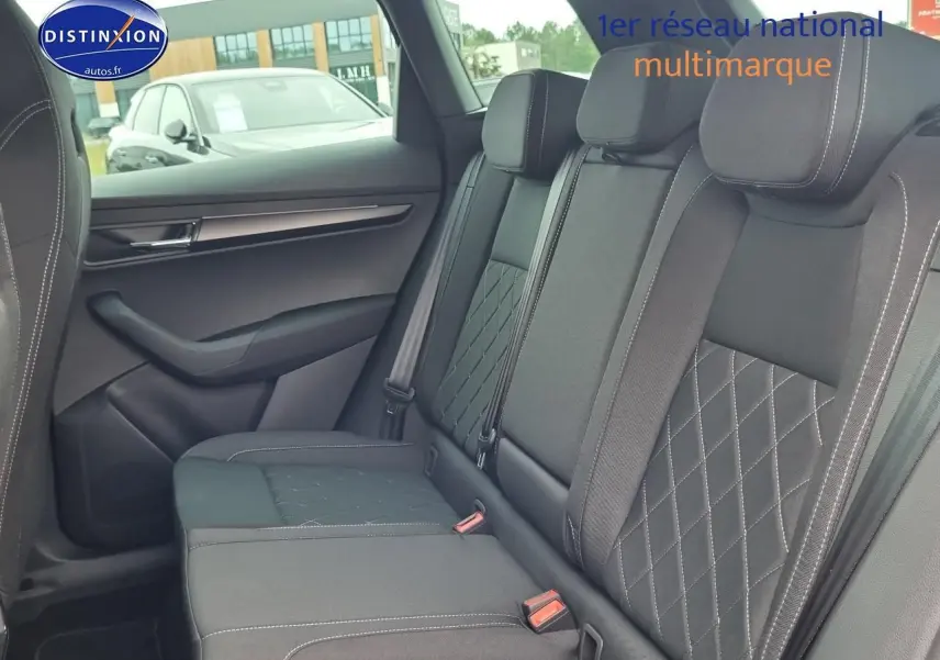 Vue intérieure côté droit sur la banquette arrière noire avec surpiqûres blanches du Skoda Karoq 1.5 TSI 150 Sportline 2025.
