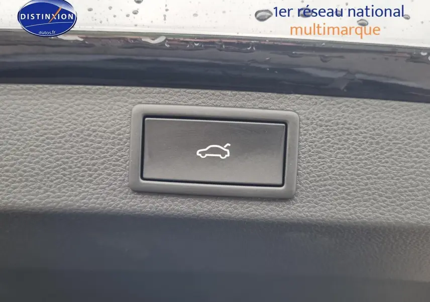 Bouton d'ouverture électrique du coffre sur tableau de bord noir d'un Skoda Karoq 1.5 TSI 2025.