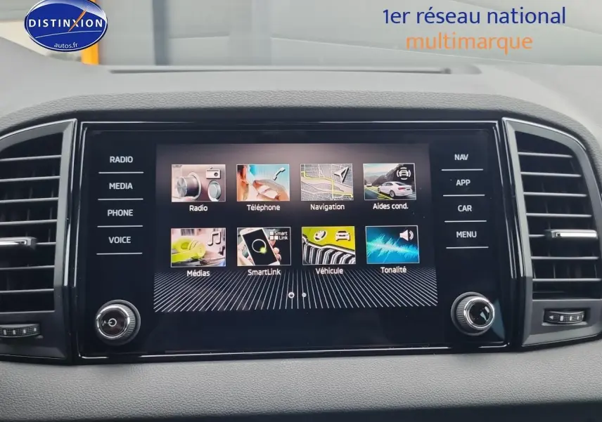 Écran tactile central du Skoda Karoq noir 2025 affichant les menus radio, navigation et véhicule, vue intérieure frontale.