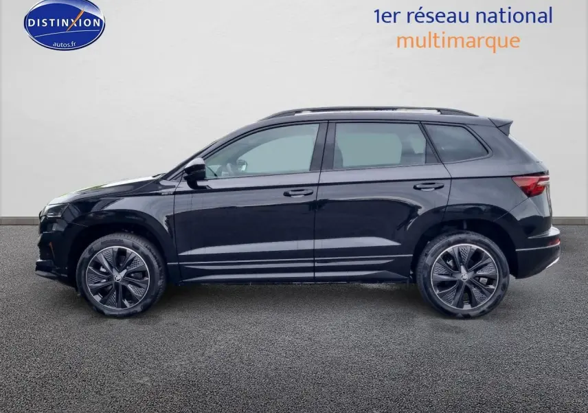 Vue de profil côté gauche d'un Skoda Karoq noir 2025 avec jantes alliage et barres de toit visibles.