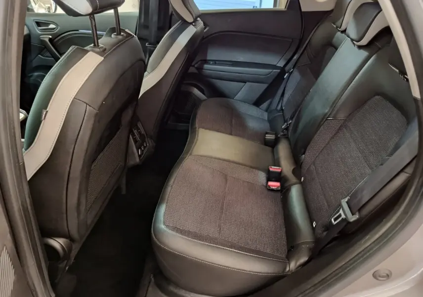 Vue intérieure côté gauche des sièges arrière gris foncé du Renault Captur Techno TCe 90 2024 avec banquette 3 places.