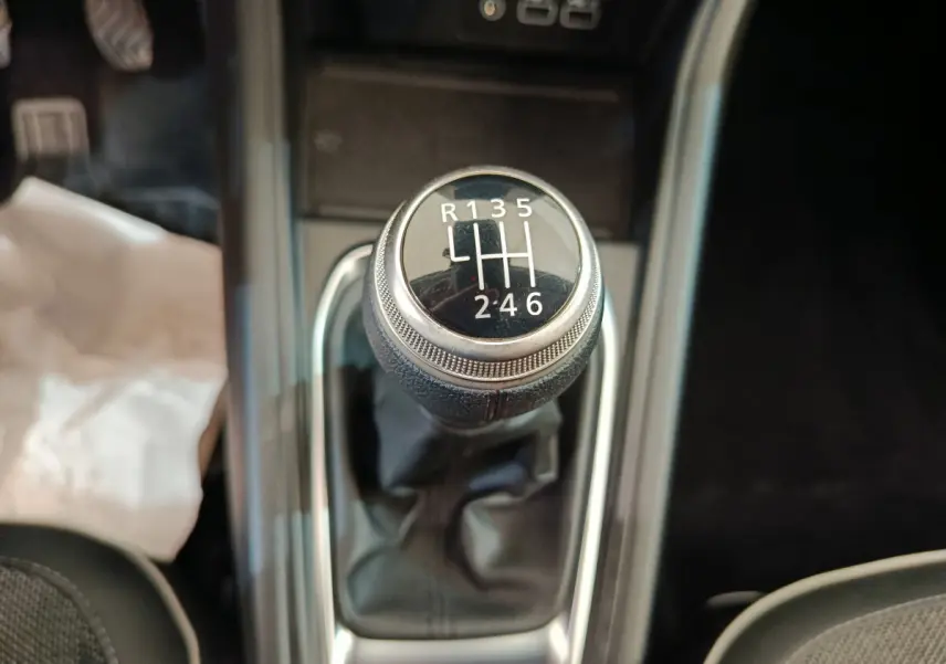 Gros plan sur le levier de vitesses manuel du Renault Captur gris foncé, avec indication des 6 rapports et marche arrière.