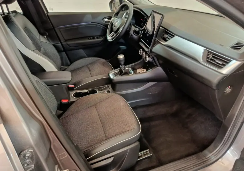 Vue intérieure côté conducteur du Renault Captur gris foncé 2024, avec tableau de bord moderne et écran tactile vertical.