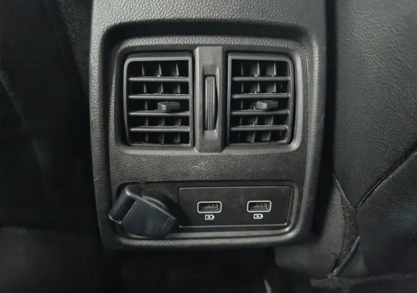 Vue rapprochée des prises USB et de la ventilation arrière noire dans l'habitacle du Renault Captur gris foncé.