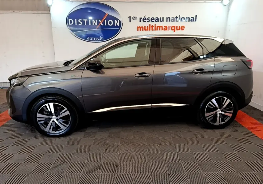 Profil côté gauche d’un Peugeot 3008 hybride rechargeable gris foncé, avec jantes alliage et toit blanc visible en intérieur showroom.