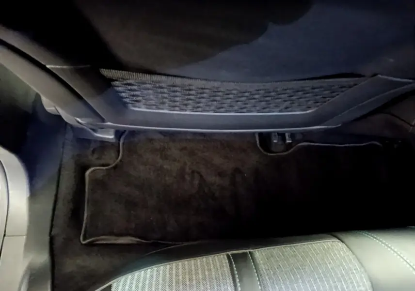 Vue intérieure côté passager avant du Peugeot 3008 gris foncé, montrant le tapis de sol et le dossier du siège.