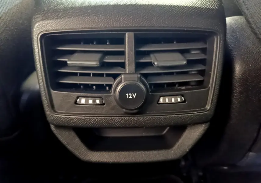 Gros plan sur la sortie d’air arrière noire avec prise 12V du Peugeot 3008 hybride gris foncé, version 2022.