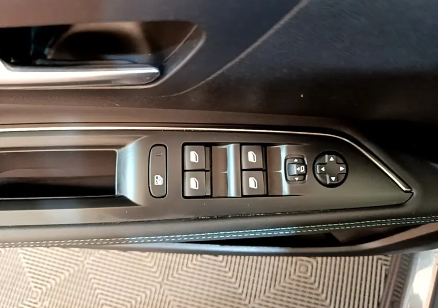 Commande des vitres et rétroviseurs côté conducteur sur porte intérieure noire avec surpiqûres bleues du Peugeot 3008 gris foncé.