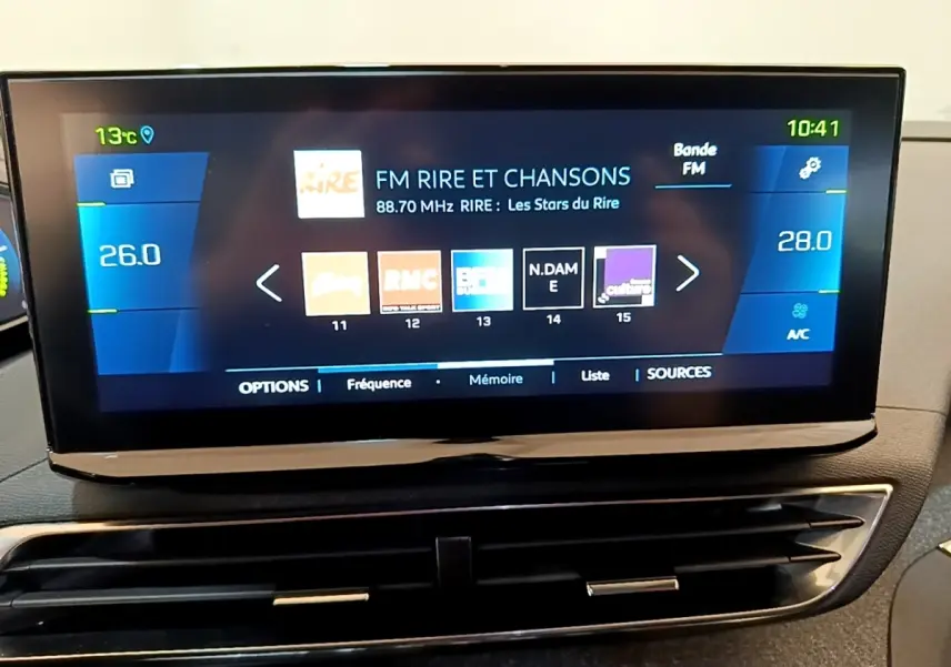 Écran tactile central du Peugeot 3008 gris foncé 2022 affichant la radio FM et la climatisation digitale.