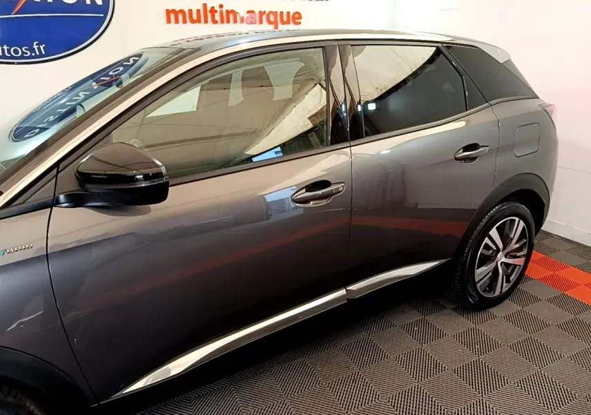 Vue latérale droite du Peugeot 3008 gris foncé hybride rechargeable, avec détails chromés et rétroviseur noir brillant.