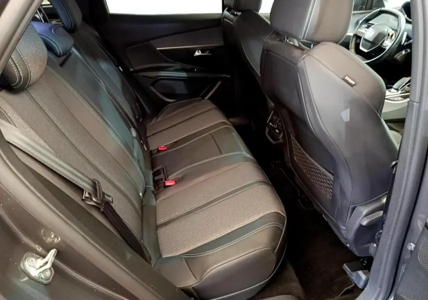 Vue intérieure côté gauche montrant la banquette arrière en tissu et cuir gris du Peugeot 3008 hybride 2022.