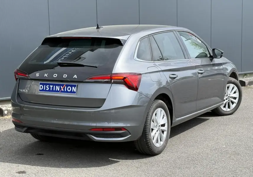 Vue 3/4 arrière droite d'une Skoda Scala TSI 116 gris graphite avec vitres surteintées et jantes alliage 16 pouces.