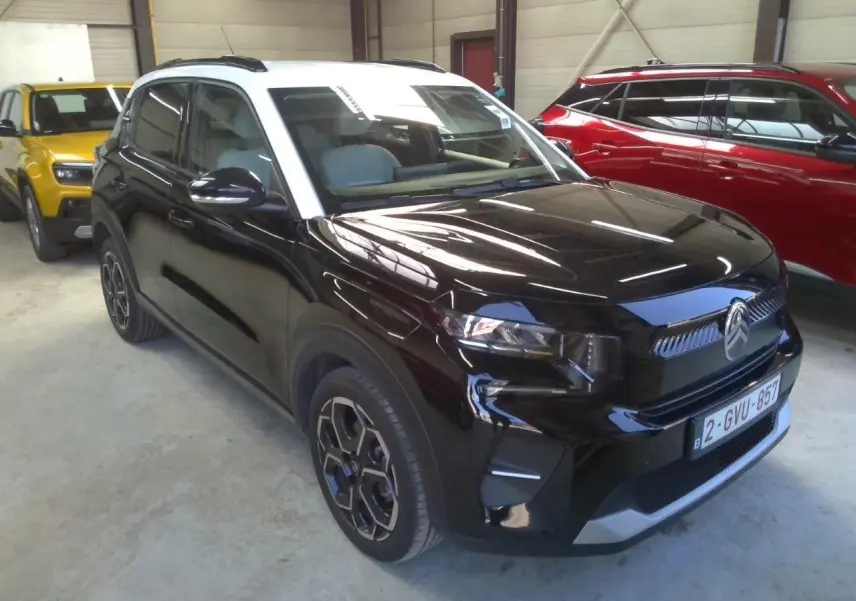 Citroën C3 1.2 Turbo 100ch Max noir perla avec toit blanc, vue 3/4 avant droit sur parking blanc.