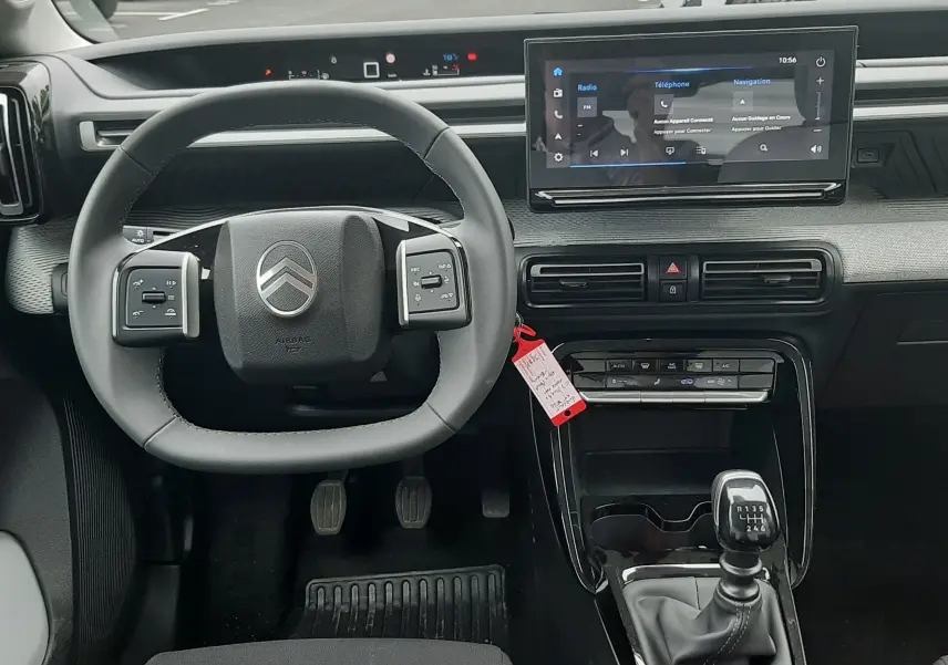 Vue intérieure frontale du tableau de bord de la Citroën C3 2025 avec volant multifonction et écran tactile central.