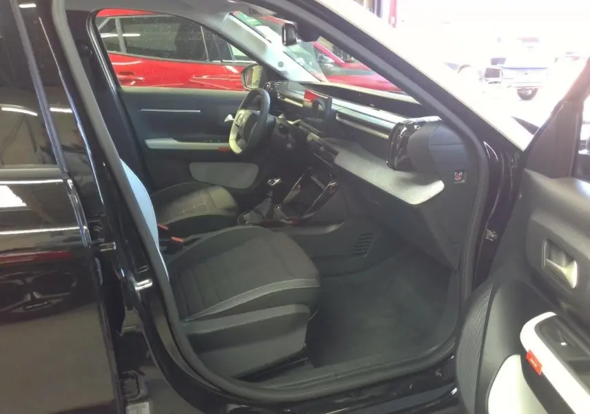 Vue avant d'une Citroën C3 2025 noir perla avec toit blanc, mettant en valeur sa calandre et ses phares LED distinctifs.