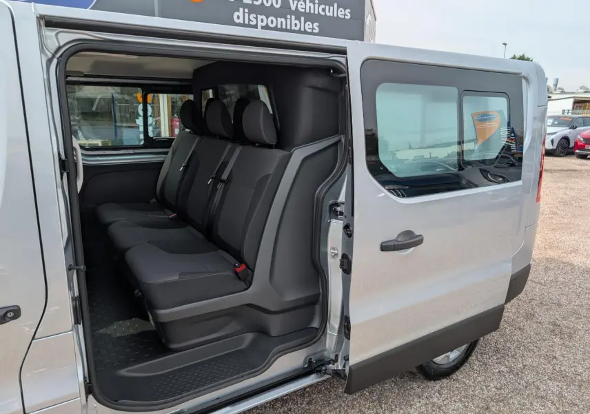 Vue côté droit sur l'ouverture de la porte coulissante d'un Renault Trafic gris avec banquette arrière 3 places.