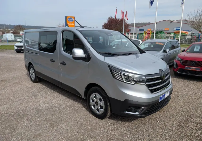 Renault Trafic Fourgon gris Highland en 3/4 avant droit, avec calandre chromée et enjoliveurs 16 pouces.