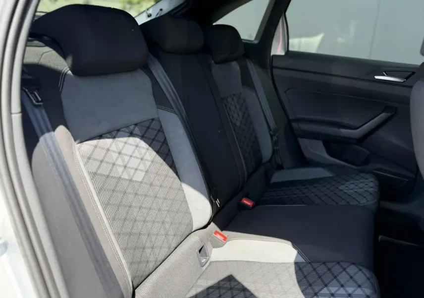 Vue intérieure de la banquette arrière du Volkswagen Taigo TSI 116 DSG R-Line, sellerie tissu noir et gris avec motifs géométriques.