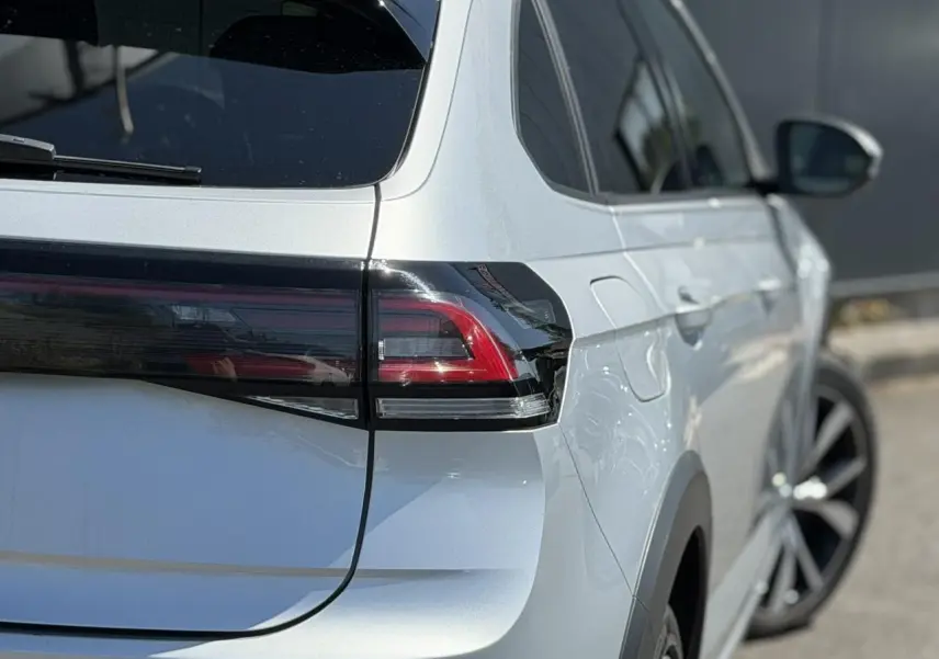 Vue 3/4 arrière droite du Volkswagen Taigo TSI 116 DSG R-Line argent Reflex, avec feux arrière LED et jantes alliage 18 pouces.