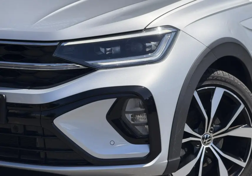 Gros plan sur l'avant droit argent Reflex du Volkswagen Taigo 2025 avec phares Matrix LED et jante alliage 18 pouces.