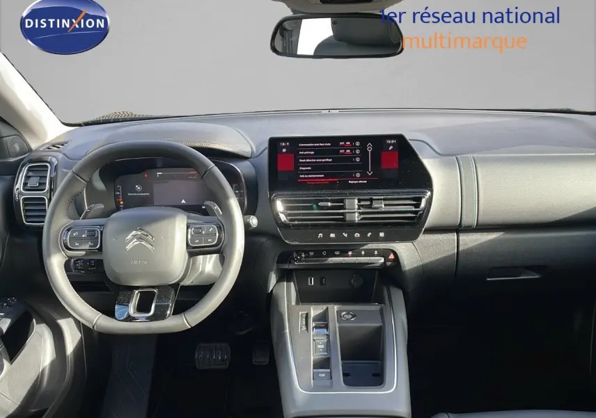 Vue intérieure avant du Citroën C5 Aircross 2025, tableau de bord et volant en cuir noir avec écran tactile central.
