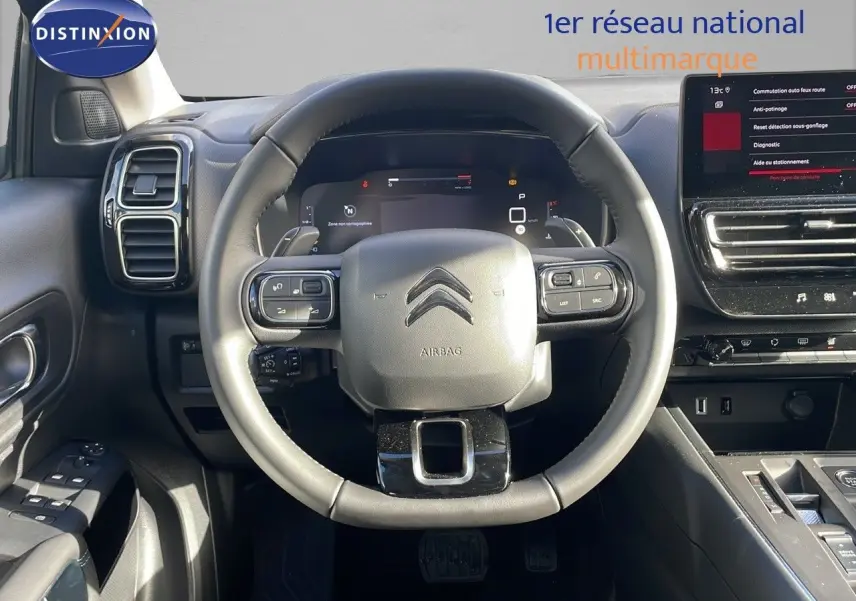 Vue centrée sur le volant cuir du Citroën C5 Aircross 2025, avec tableau de bord numérique et écran tactile.