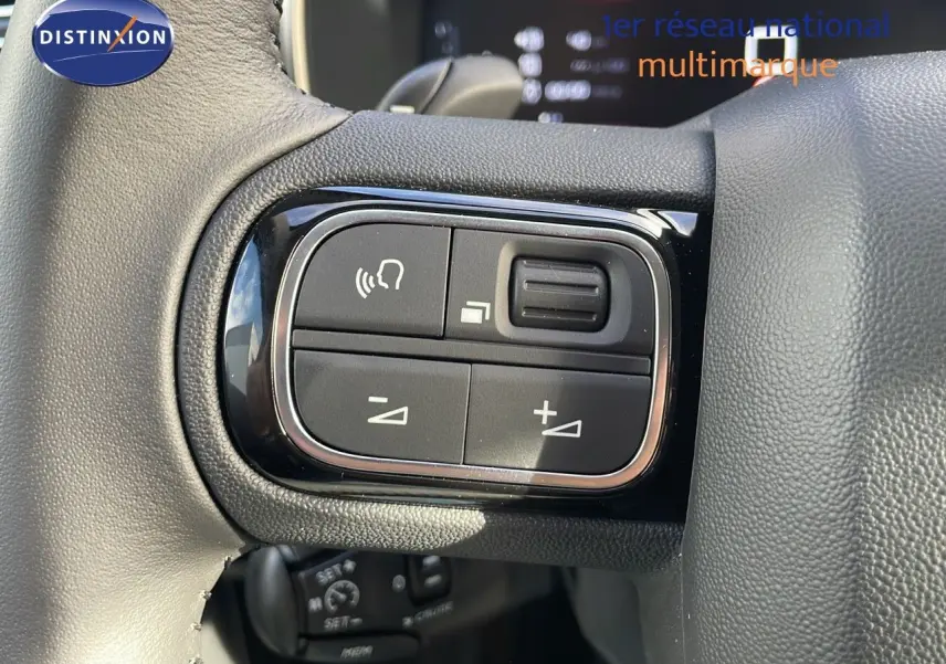 Gros plan sur les commandes de volume et appel au volant en cuir noir du Citroën C5 Aircross bleu Eclipse Metal 2025.