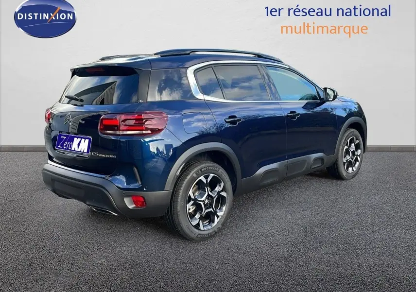Vue 3/4 arrière droite d'un Citroën C5 Aircross bleu Eclipse Metal avec jantes alliage et protections noires.