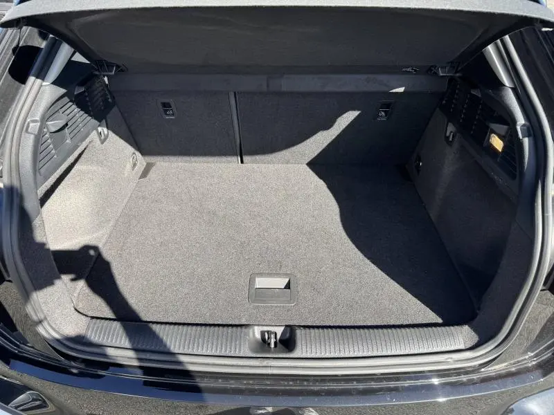 Coffre ouvert vu de l'arrière d'un Audi Q2 35 TFSI S line 2023 noir Mythic métallisé, espace de chargement vide et propre.