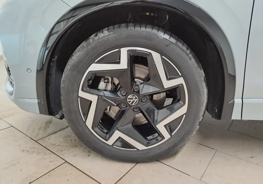 Gros plan sur la roue avant gauche du Volkswagen Tiguan 2025 argent Dolomite avec jante alliage noire et argentée R-Line.