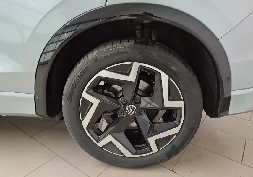 Gros plan sur la roue arrière droite argent Dolomite du Volkswagen Tiguan 2025 avec jante noire et argentée distinctive R-Line.