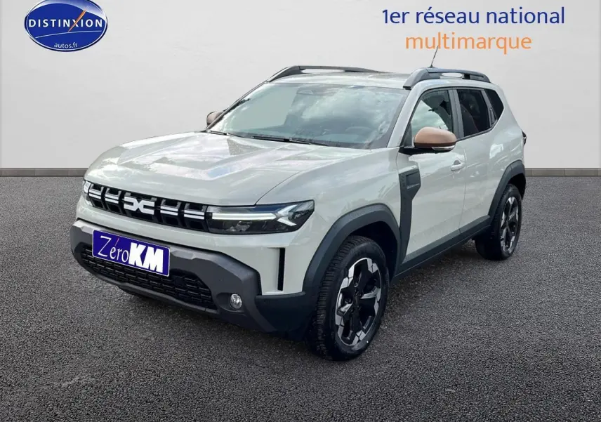 Vue 3/4 avant du Dacia Duster 2025 couleur Sandstone avec barres de toit et jantes alu noires.