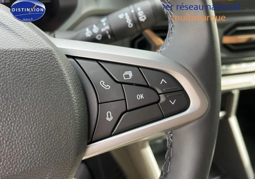 Gros plan sur les commandes multifonctions à droite du volant du Dacia Duster 2025 couleur Sandstone.