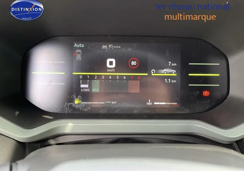 Tableau de bord numérique du Dacia Duster 2025 affichant vitesse, régime moteur et alertes, vue de face rapprochée.