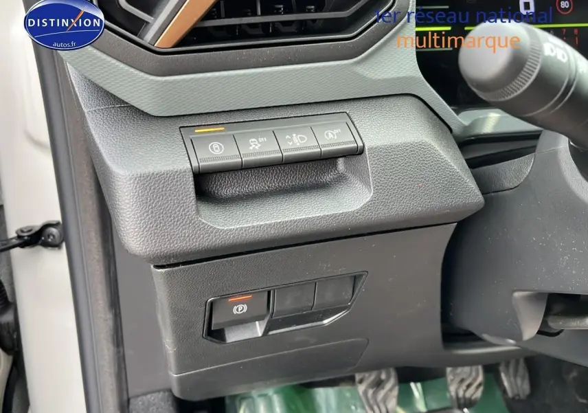 Détail des commandes sous le tableau de bord côté gauche du Dacia Duster 2025 couleur Sandstone.