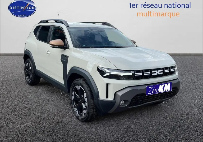 Vue 3/4 avant du Dacia Duster 2025 couleur Sandstone avec jantes noires et barres de toit visibles.