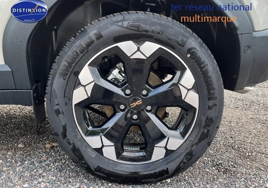 Gros plan sur la jante alu noire et argentée du Dacia Duster 2025 couleur Sandstone, vue côté droit.