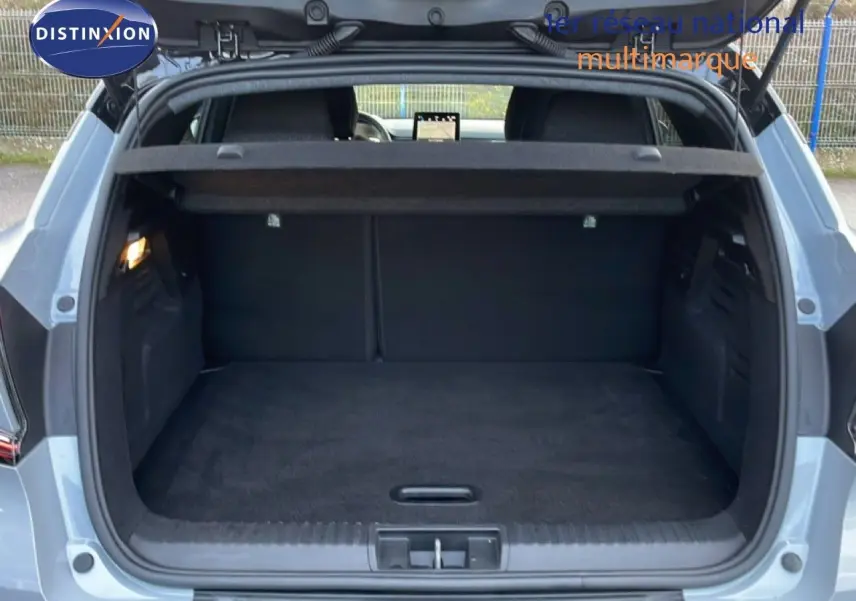 Coffre ouvert vu de l'arrière d'un Renault Captur gris Rafale métal avec toit noir, intérieur de coffre noir.