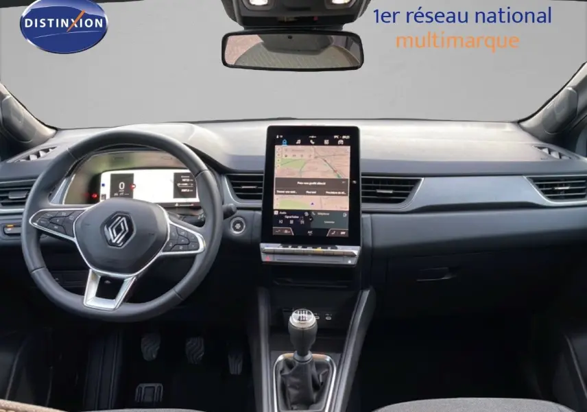 Vue intérieure frontale du tableau de bord du Renault Captur gris Rafale métal avec écran tactile vertical et boîte manuelle.