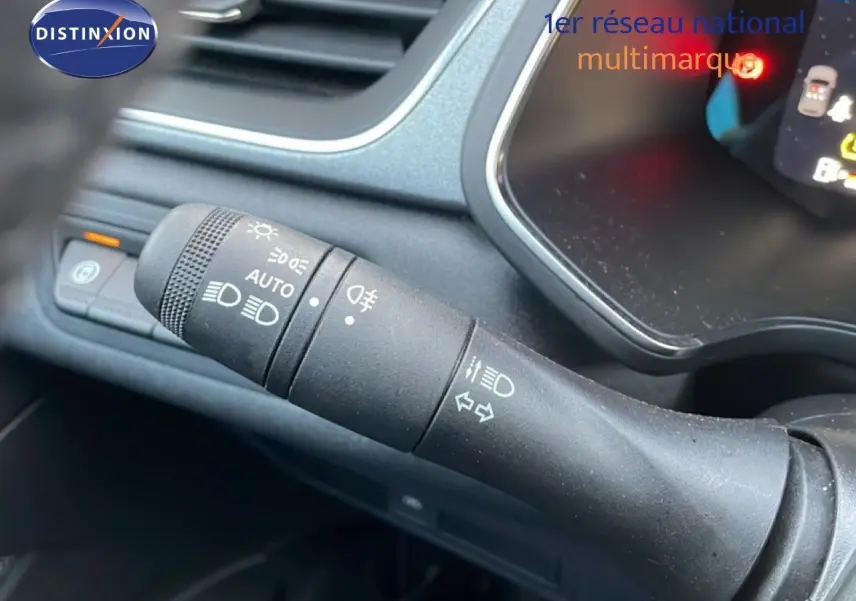 Gros plan sur la manette de commande des phares et clignotants dans l'habitacle du Renault Captur gris Rafale Métal.