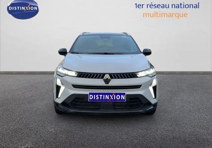 Vue avant d'un Renault Captur 1.0 ECO-G 100ch Techno gris Rafale métal avec toit noir, feux LED allumés.