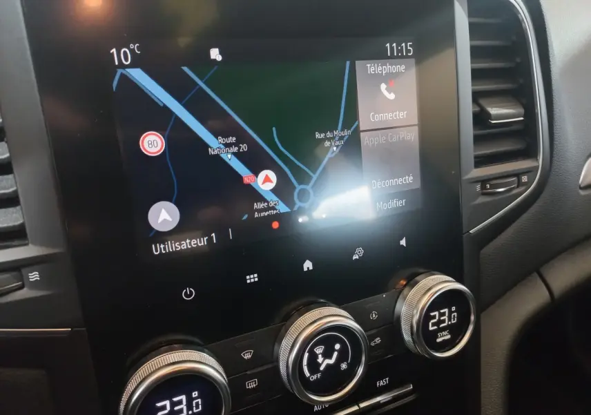 Vue rapprochée de l’écran tactile central et des commandes de climatisation d’une Renault Mégane Business gris foncé de 2022.