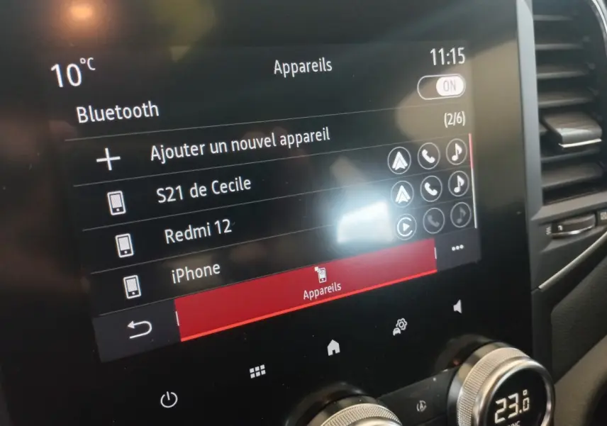 Écran tactile central de la Renault Mégane Business gris foncé, affichant menu Bluetooth et commandes climatisation.